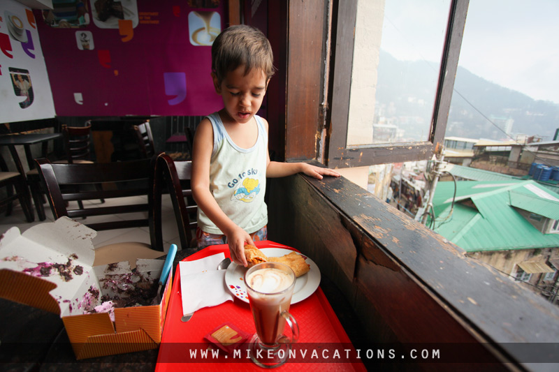 Child drinking hot chocolate mountain cafe Manali family travel