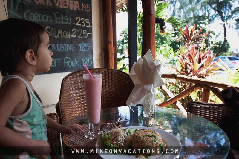 Child eating Thai fried rice with chicken at a seaside restaurant in Pattaya